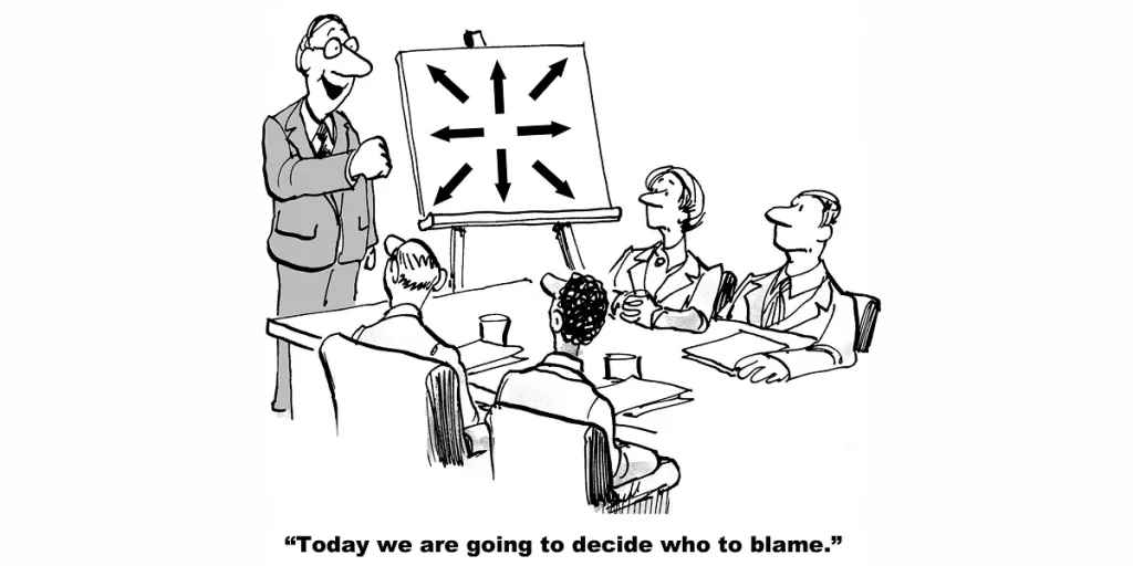 Cartoon: Ein Vorgesetzter steht vor einem Flipchart mit Pfeilen in alle Richtungen und verkündet seinem Team: „Heute entscheiden wir, wen wir beschuldigen.“